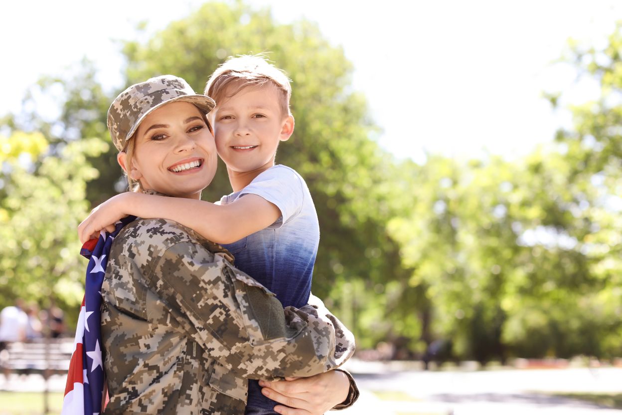 woman military service member holds child smiling